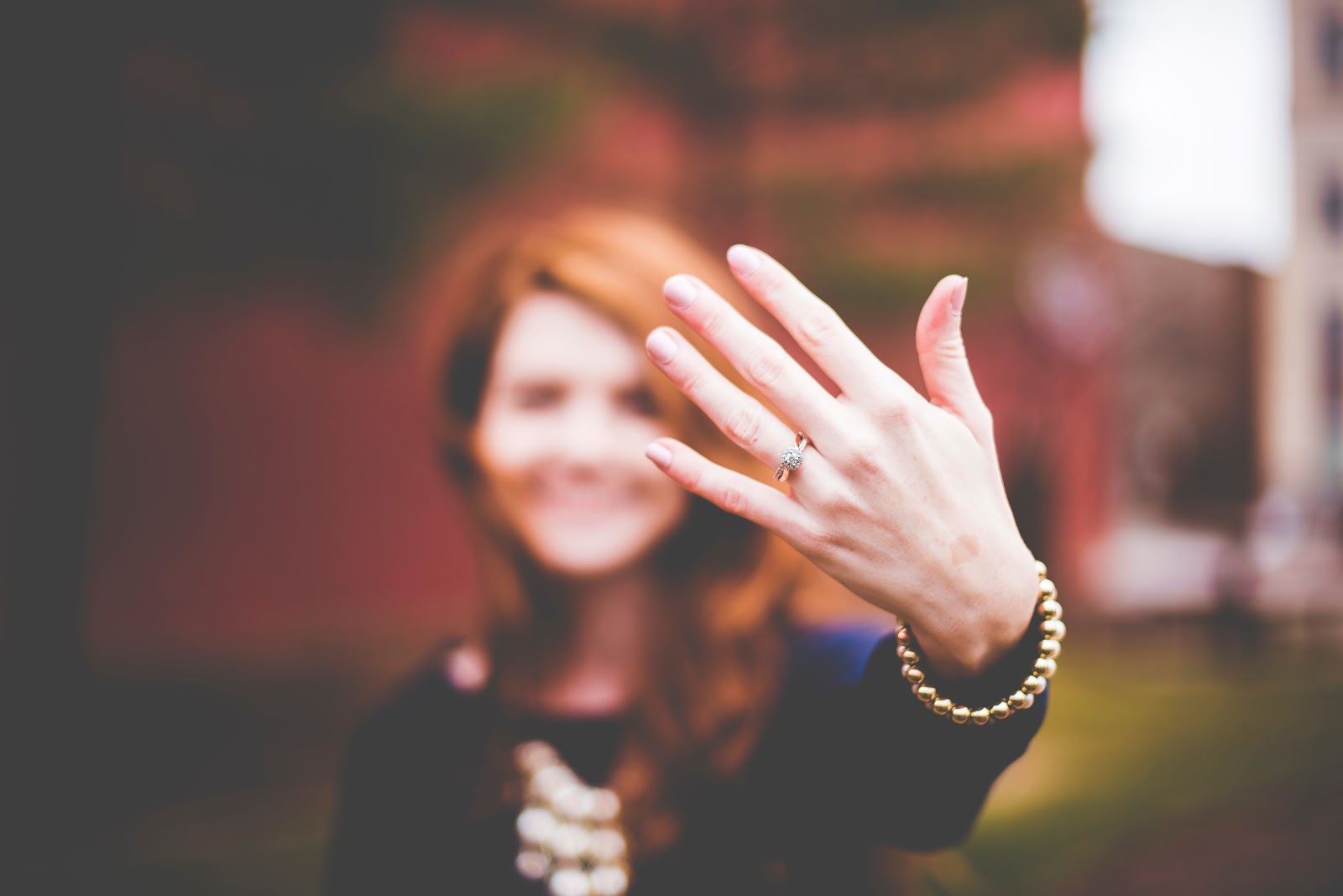 select focus of woman holding left hand toward camera displaying engagement ring