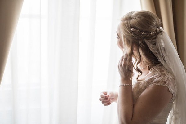 a bride putting on her wedding jewelry